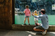 A family looking at an aquatic enclosure at John Ball Zoo.