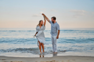 A couple on a beach at sunset. 