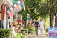 Two men holding hands outside shops in downtown Saugatuck.