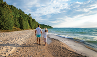 A couple walking on a Lake Michigan beach.