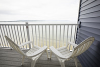 Deck chairs on a balcony over a bay.
