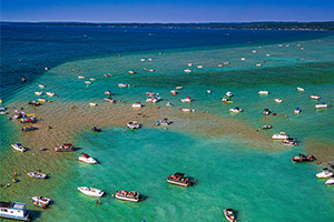 Boats around a sandbar in Torch Lake.