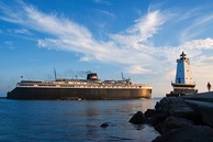 A ship passing a lighthouse on Lake Michigan. 