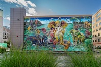 A mural of people and animals on the side of a building in Grand Rapids.