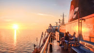 A couple watching the sunset on Lake Michigan from the deck of the S.S. Badger ship. 
