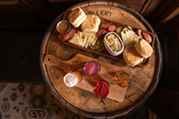 A charcuterie board displayed on a barrel.