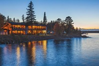 A restaurant with windows overlooking the shore of Lake Superior after sunset. 