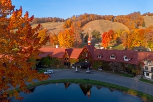 A alpine-style lodge surrounded by fall trees. 