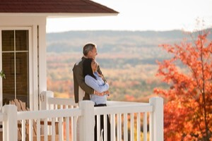 A couple on a balcony overlooking a fall landscape. 