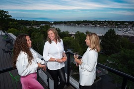 A group of women enjoying beverages on a rooftop bar. 