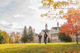A couple strolling with coffees outside the Grand Traverse Commons historic buildings. 