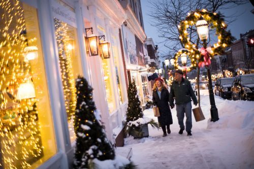 A couple walking by holiday displays in shop windows in downtown Petoskey. 
