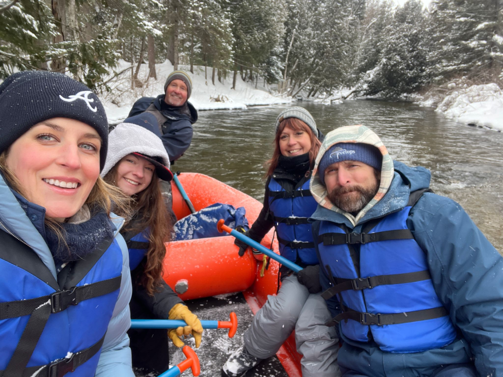 Anja Richter winter rafting with a group of travelers on a river. 