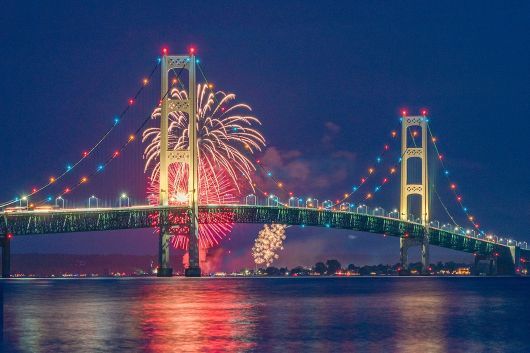 Fireworks above the Mackinac Bridge at night.