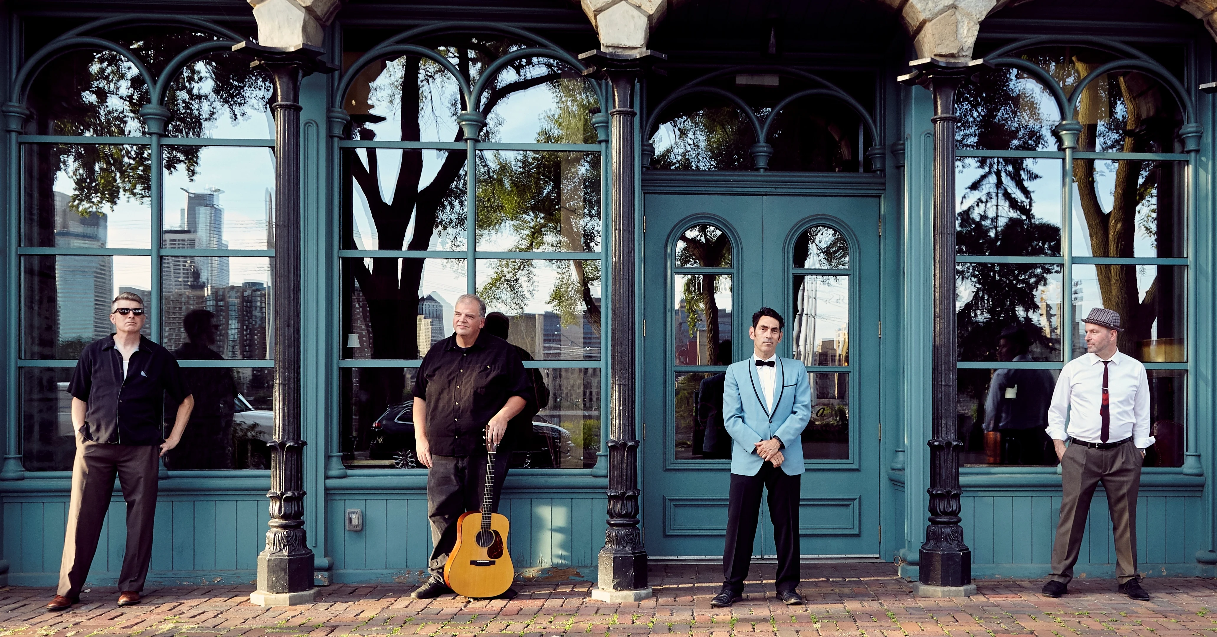 four musicians standing outside