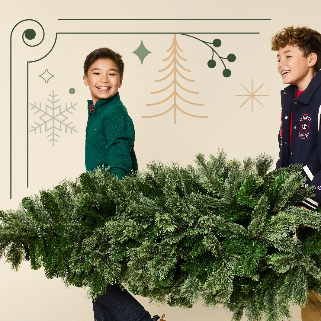 two children carrying a pine tree