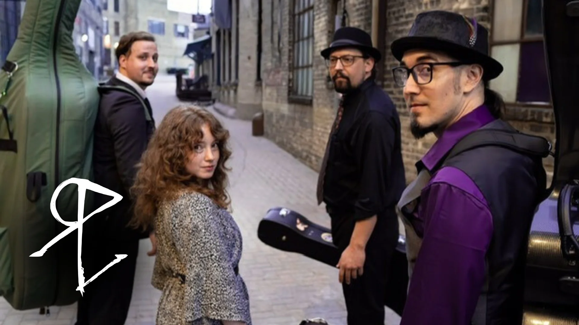 three men and a woman look back at you while standing in an alley