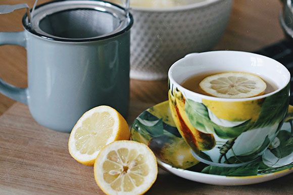 a cup of tea and lemon on a table