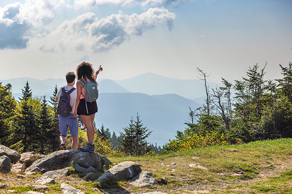 a man and woman hiking, pointing at views