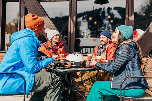 a group of friends with drinks on a deck apres ski