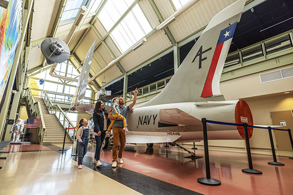 a family inside a museum with a rocketship