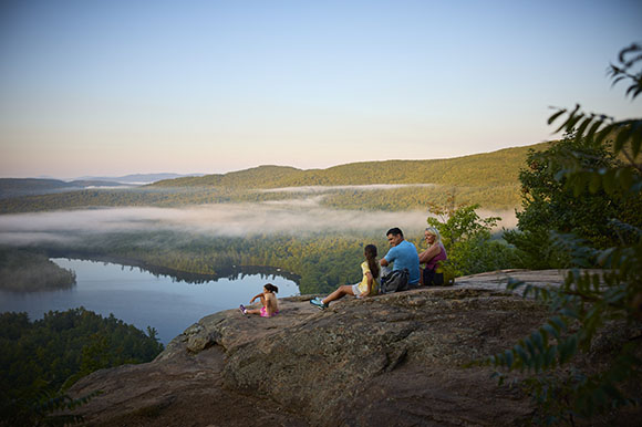 a family sitting on rocks at the summit of a hike