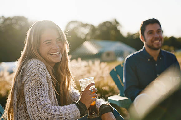 a woman with a beer outside in fall