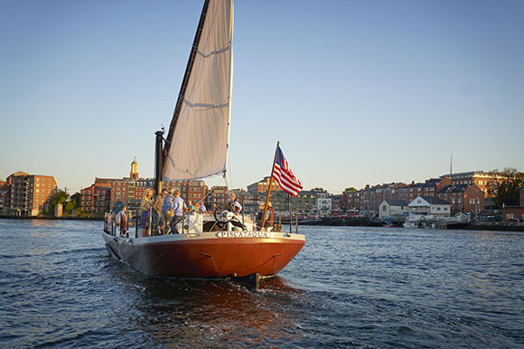 a boat sailing with brick buildings in the background