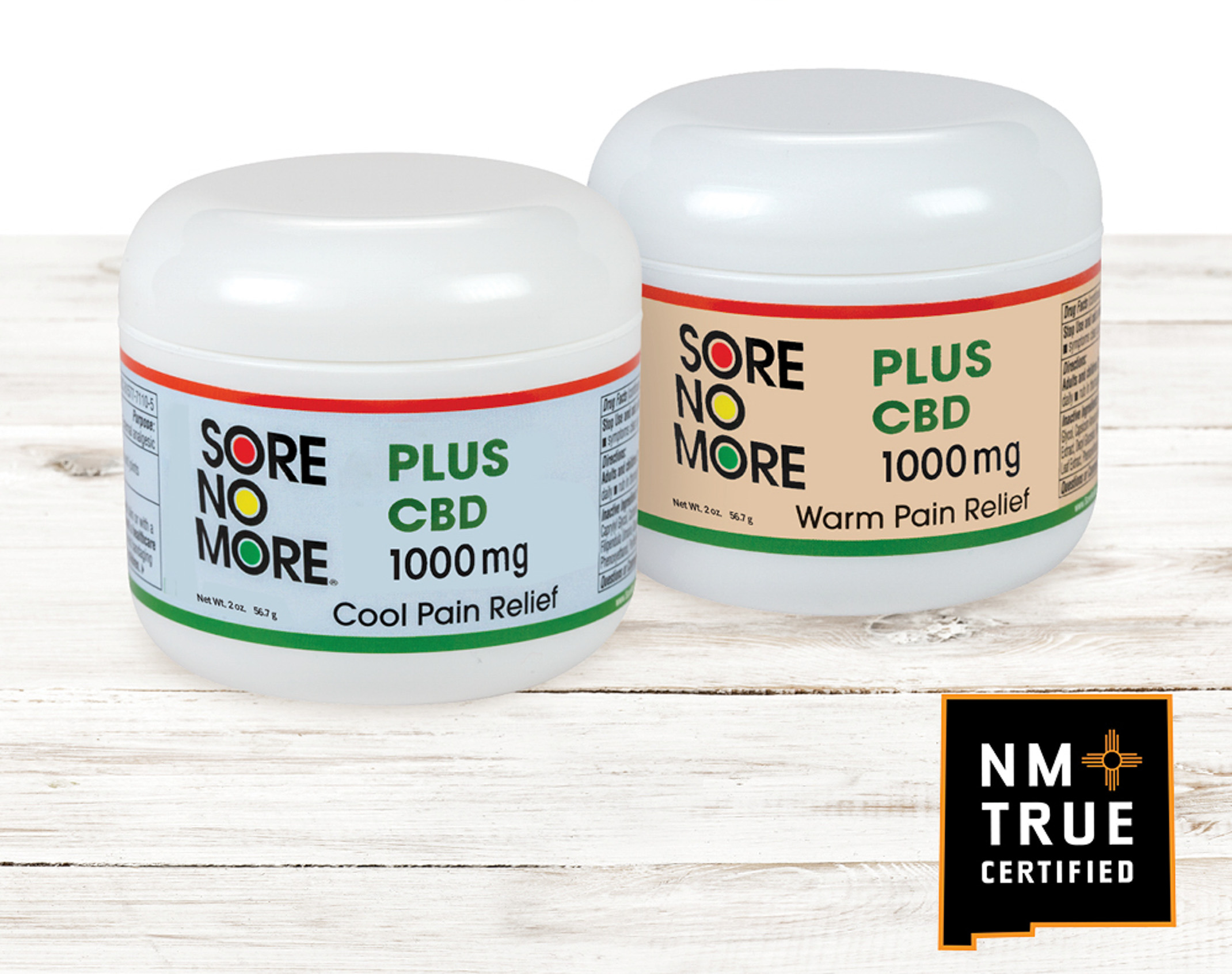 Two containers of "Sore No More" pain relief cream from the brand Plus CBD, one labeled as "Cool Pain Relief" and the other as "Warm Pain Relief," on a wooden surface with a white background and a "NM True Certified" logo visible.