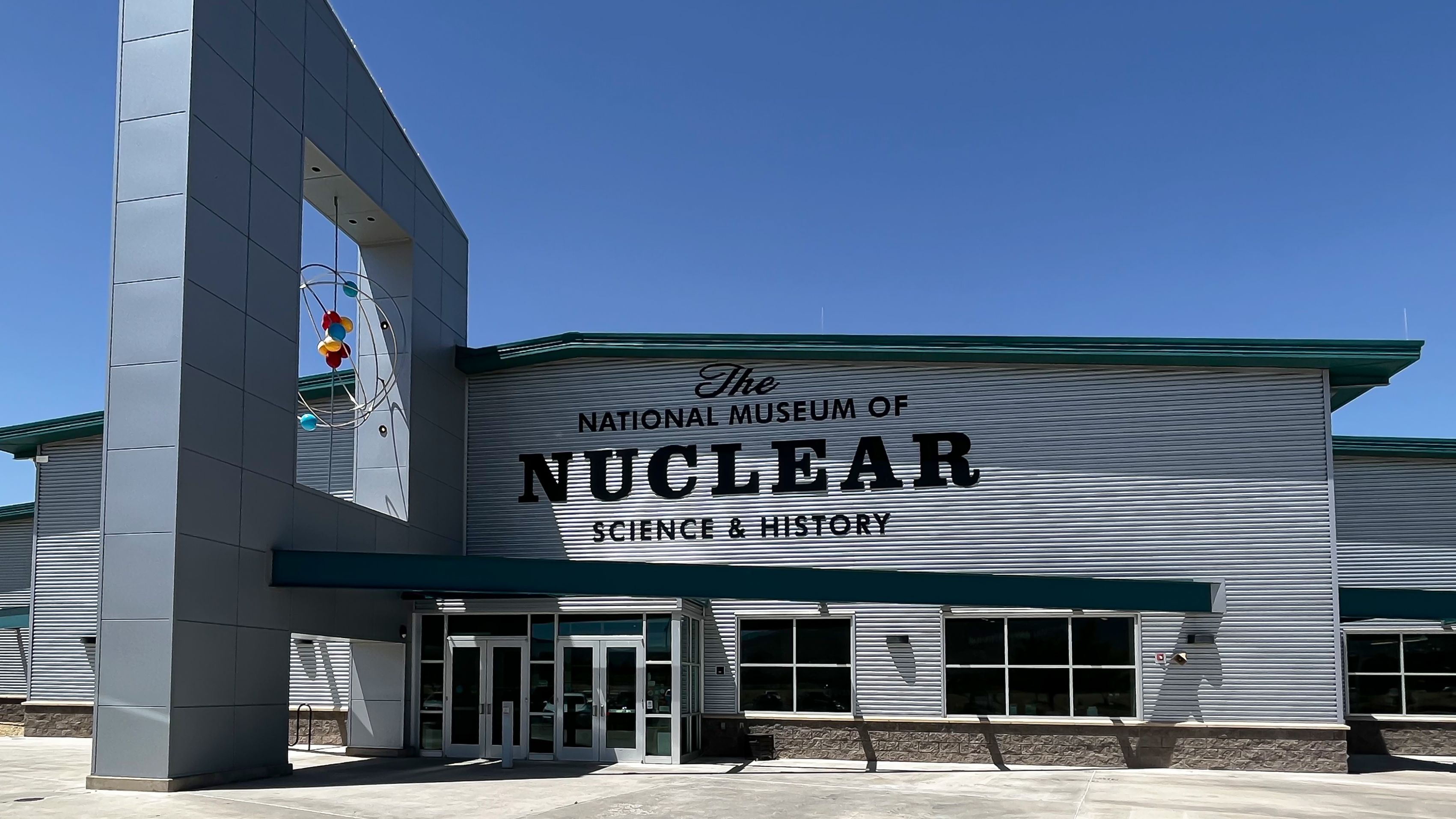 Exterior view of The National Museum of Nuclear Science & History under a clear sky, showcasing its modern architecture and prominent entrance.