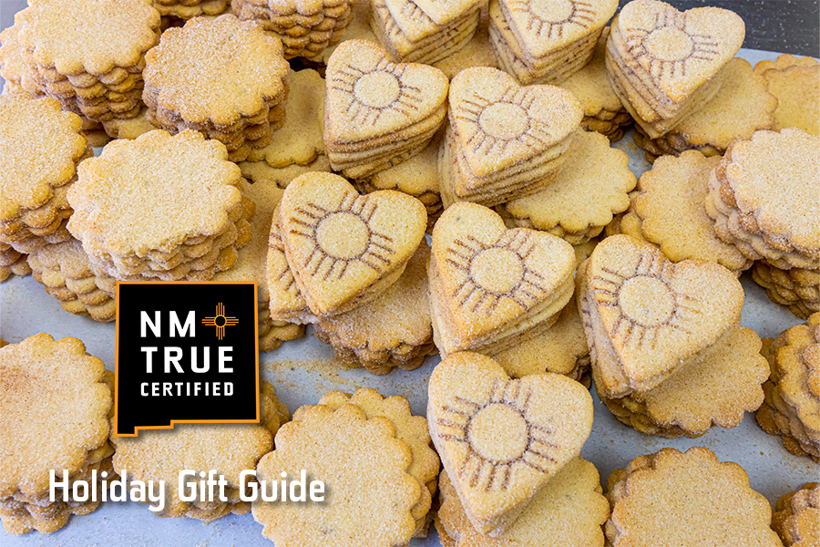 Array of heart-shaped cookies with decorative imprints, featuring the 'NM True Certified' logo, part of a Holiday Gift Guide.