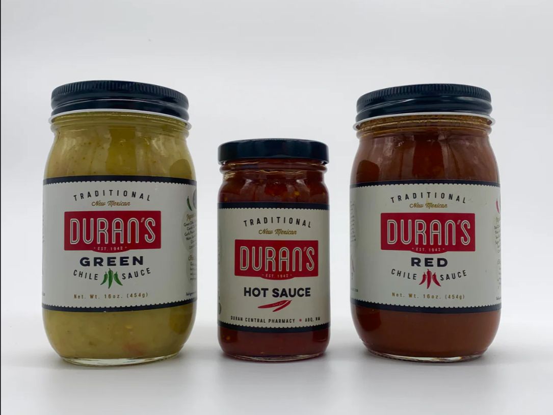 Three jars of Duran's sauces on a white background, from left to right: green chile sauce, hot sauce, and red chile sauce.