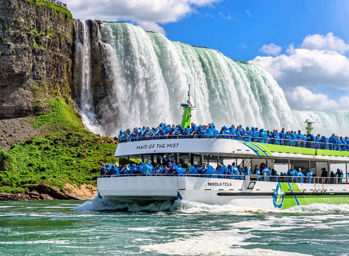 Visitors in blue ponchos ride the Maid of the Mist boat toward the powerful Horseshoe Falls at Niagara Falls.