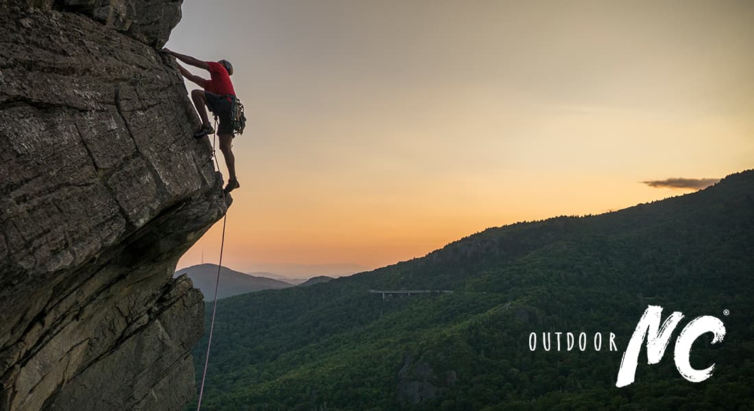 Outdoor NC - man rock climbing Ship Rock at sunset