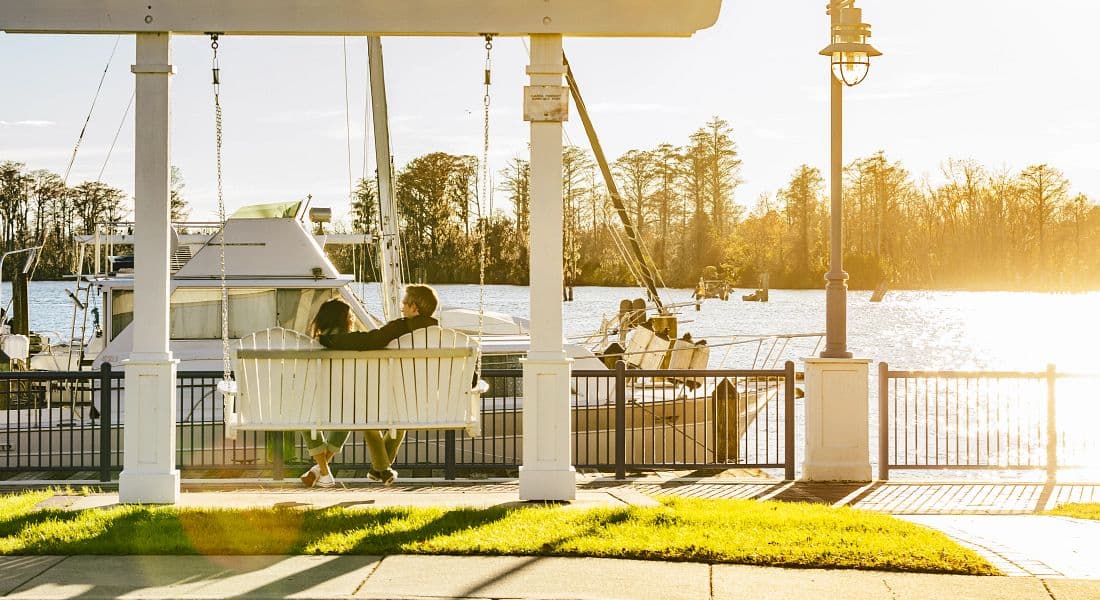 Couple swinging along waterfront in Downtown Washington along the Pamlico River