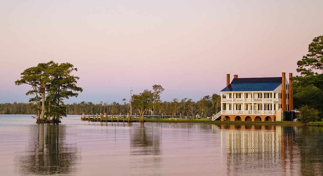 Wide view of Barker House from water on Albemarle sound at sunset in Edenton