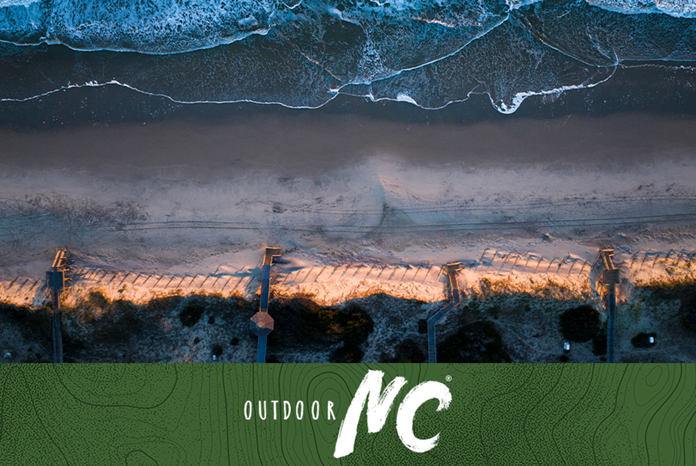 Ariel view of Corolla Beach, North Carolina with board walks, beach and ocean at sunrise. 