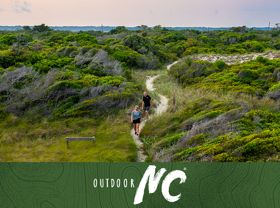 Two people hike the dunes on Bird Island in Sunset Beach, NC. 
