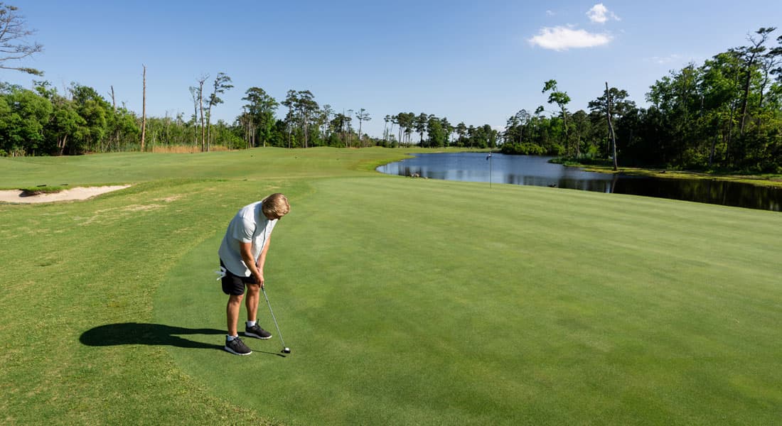 Golfer lining up a putt on a picturesque green