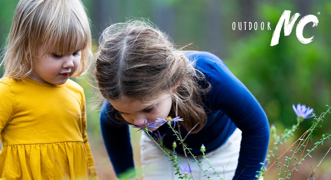 OUTDOOR NC - two young girls smelling flowers