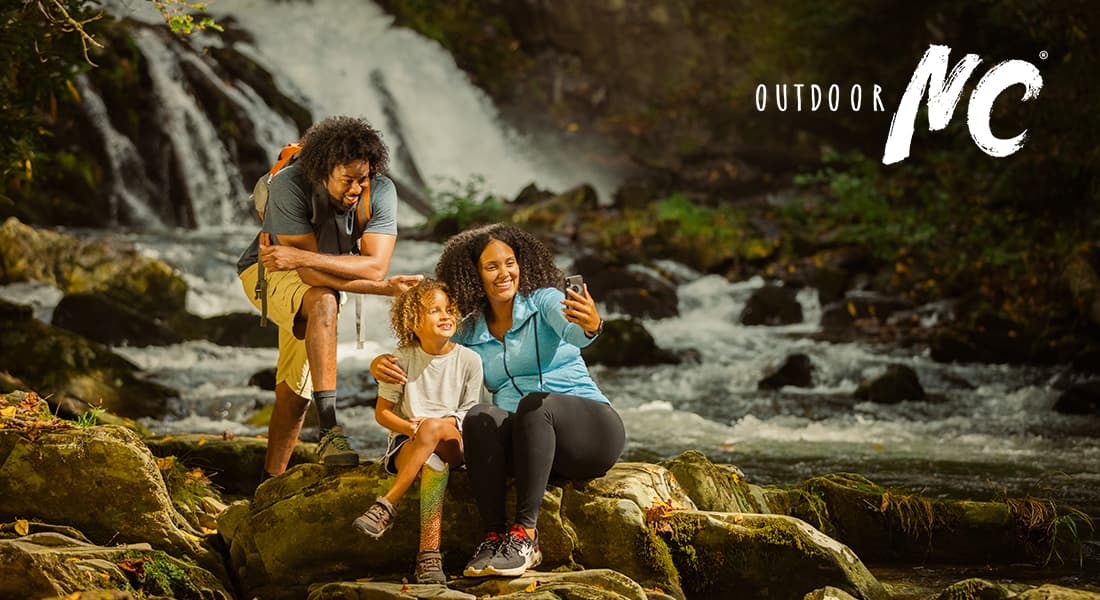 OUTDOOR NC - Family taking a selfing in front of a waterfall