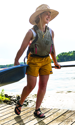 A woman getting ready to paddle in NC wearing proper gear like a PFD.