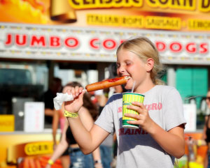 Young girl eating a corndog