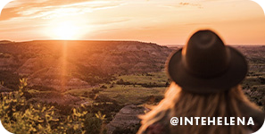 View of back of woman's head and a scenic view of the sunset