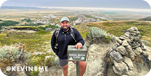 Smiling man on a mountain, with overlay text that reads: @kevinbme