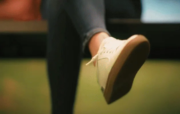 GIF of a woman on a bench reading an oversized travel guide while tapping her foot and fingers