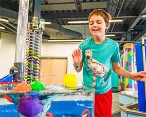 Young boy interacting with an exhibit at a museum