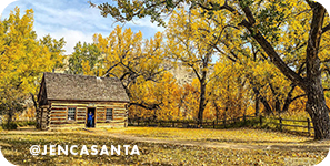 A log cabin surrounded by trees with changing yellow leaves, with overlay text that reads: @jencasanta