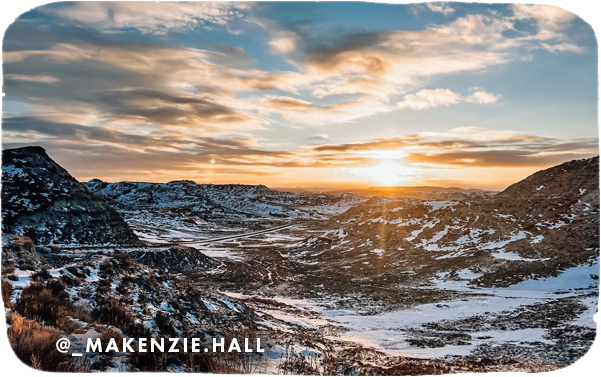 View of snowy mountains with the sun and clouds in the distance, with overlay text that reads: @_makenzie.hall