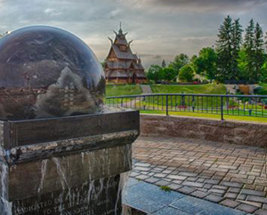 Scenery of a large water fountain and a unique building in the background